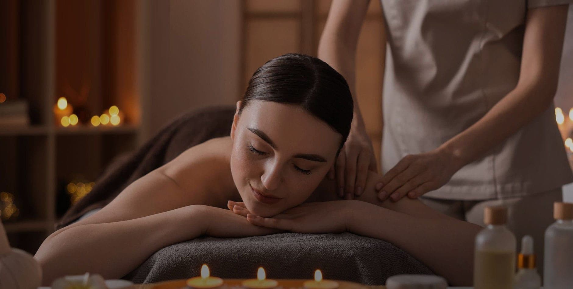 Therapist giving a candlelit shoulder massage